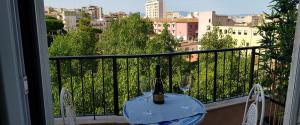 una mesa con una botella de vino y 2 copas en el balcón en San Lucifero Home & Relax - IUN 1871 en Cagliari