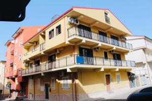 a yellow building with balconies on a street at elegance b&b in Cariati