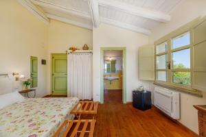 a bedroom with a bed and two benches in it at Wine Resort Ledà d'Ittiri in Alghero