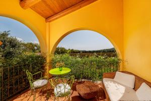 a patio with a table and chairs on a balcony at Wine Resort Ledà d'Ittiri in Alghero