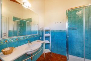 a blue bathroom with a sink and a shower at Wine Resort Ledà d'Ittiri in Alghero