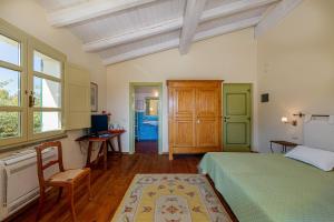 a bedroom with a bed and a desk and window at Wine Resort Ledà d'Ittiri in Alghero