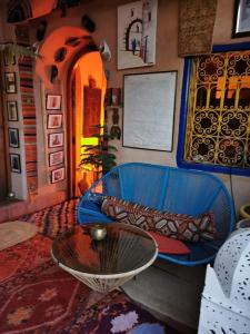 a living room with a blue couch and a table at Ayouze Auberge in Aït Ben Haddou