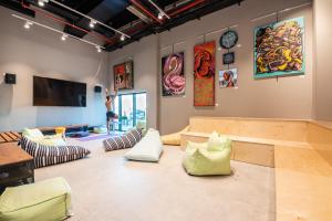 Habitación con sofás y pinturas en las paredes. en The Spot Hostel, en Tel Aviv