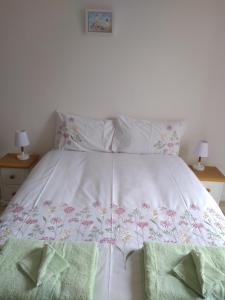 a white bed with two green towels on it at Stylish two bedroom apartment in St Andrews centre in St. Andrews