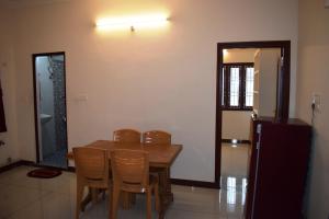 a dining room with a wooden table and chairs at White Tulip Residency in Puducherry