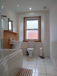 a bathroom with a toilet and a sink and a window at Stylish two bedroom apartment in St Andrews centre in St. Andrews