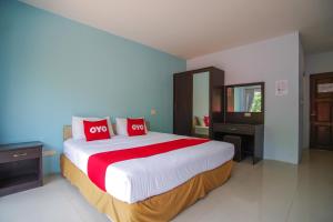 ein Schlafzimmer mit einem großen Bett mit roten Kissen in der Unterkunft OYO 384 Ban Sabaidee in Phra Nakhon Si Ayutthaya
