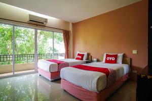 2 Betten in einem Zimmer mit einem großen Fenster in der Unterkunft OYO 384 Ban Sabaidee in Phra Nakhon Si Ayutthaya