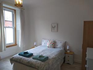 a bedroom with a bed with two towels on it at Stylish two bedroom apartment in St Andrews centre in St. Andrews
