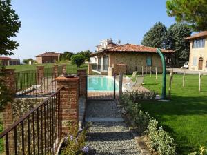 un patio trasero con piscina y una casa en Azienda Agricola Garoglio Davide, en Alfiano Natta