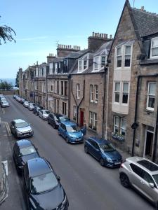 a row of cars parked on the side of a street at Stylish two bedroom apartment in St Andrews centre in St. Andrews