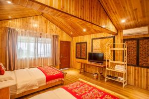 een slaapkamer met een bed en een tv in een kamer bij Long An Hotel in Longsheng