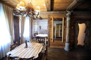 a dining room with a wooden table and a chandelier at ООО РГК Русская охота in Penza