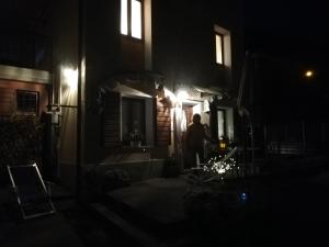 une personne debout à l'extérieur d'une maison la nuit dans l'établissement Casetta next to the Creek Dino Buzzati, à Belluno