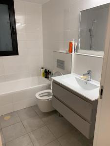 a white bathroom with a sink and a toilet at Meir Yaari 20 in Tel Aviv