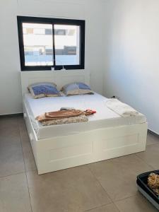 a white bed in a room with a window at Meir Yaari 20 in Tel Aviv