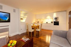 a living room with a table and a kitchen at Tavistock Place Apartments in London