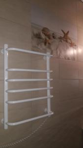 a white towel rack on the wall in a bathroom at Re-Ka Luxury Apartments in Odesa