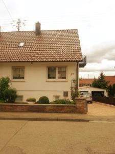uma casa branca com um carro estacionado em frente dela em Ferienhaus Brit em Tailfingen