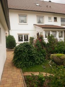 a white house with a brick driveway in front of it at Ferienhaus Brit in Tailfingen