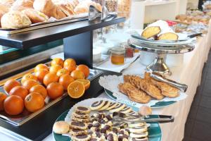 una línea de buffet con diferentes tipos de pan y repostería en Hotel Garden en Albissola Marina