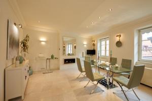 a large living room with a glass table and chairs at President Mezonet Apartment in Brno