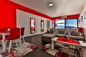 a living room with red walls and a couch and a table at Beachfront RED APARTMENTS With Pool in Bar