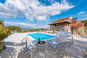 a house with a swimming pool and a patio at Vila Luna Apartments in Zadar