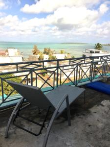 a table and a bench on a balcony with the ocean at Villa Les Aigrettes in Mahébourg