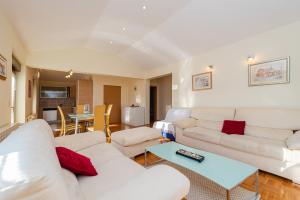a living room with white couches and a table at Vila Luna Apartments in Zadar