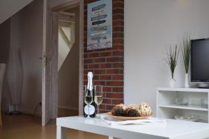 a white table with a bottle of wine and a glass at Ferienwohnung Hafenwestseite Neustadt in Neustadt in Holstein