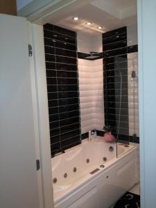 a bathroom with a bath tub with a window at Apartment 33 in Hotel Iceberg in Borovets