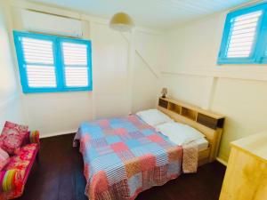 En eller flere senge i et værelse på Location Maison Bleue avec piscine privative au Carbet Martinique