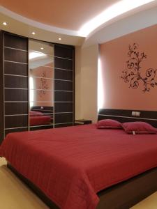 a bedroom with a red bed and a mirror at Apartment 33 in Hotel Iceberg in Borovets