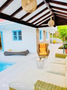 eine Terrasse mit Gartenmöbeln und einem Pool in der Unterkunft Location Maison Bleue avec piscine privative au Carbet Martinique in Le Carbet