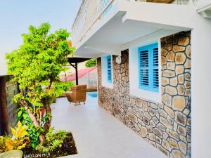 eine Terrasse eines Hauses mit einer Steinmauer in der Unterkunft Location Maison Bleue avec piscine privative au Carbet Martinique in Le Carbet