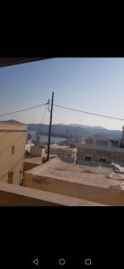 a view from a window of a city with buildings at Soulas apart -Ρέα- in Ano Syros