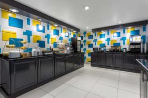 a restaurant with a buffet line with colorful walls at La Quinta by Wyndham Columbus West - Hilliard in Columbus