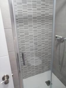 La salle de bains est pourvue d'une douche avec une porte en verre. dans l'établissement Estudio FARO TORROX-1ª línea playa, à Torrox Costa