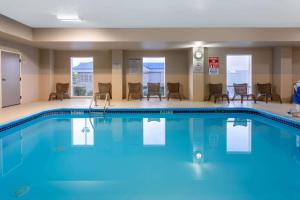 una piscina en una habitación de hotel con sillas y mesas en La Quinta by Wyndham Columbus West - Hilliard, en Columbus