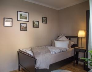 a bedroom with a bed with a lamp and pictures on the wall at Feriendomizil Renate in Bad Sobernheim