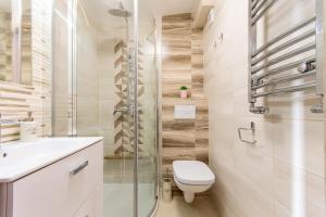 a bathroom with a toilet and a glass shower at Illusione in Pobierowo