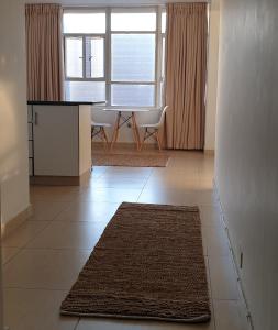 a living room with a table and a rug on the floor at 904 Tenbury Beach Apartment in Durban