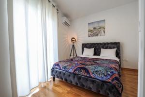 a bedroom with a bed and a large window at Sunny Side Wellness Resort & Spa in Budva
