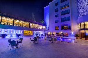 a courtyard with chairs and tables in a building at night at Amman International Hotel in Amman