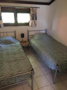 two twin beds in a room with a window at Strandjutter huisje 8 in Middelkerke