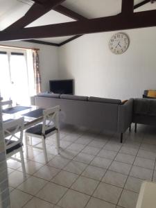 a living room with a couch and a clock on the wall at Strandjutter huisje 8 in Middelkerke