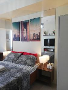 um quarto com uma cama e uma televisão de ecrã plano em JDT's Condo at Horizons 101 Cebu em Cebu