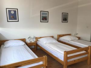 2 Betten in einem Zimmer mit 3 Bildern an der Wand in der Unterkunft City Inn in Berlin